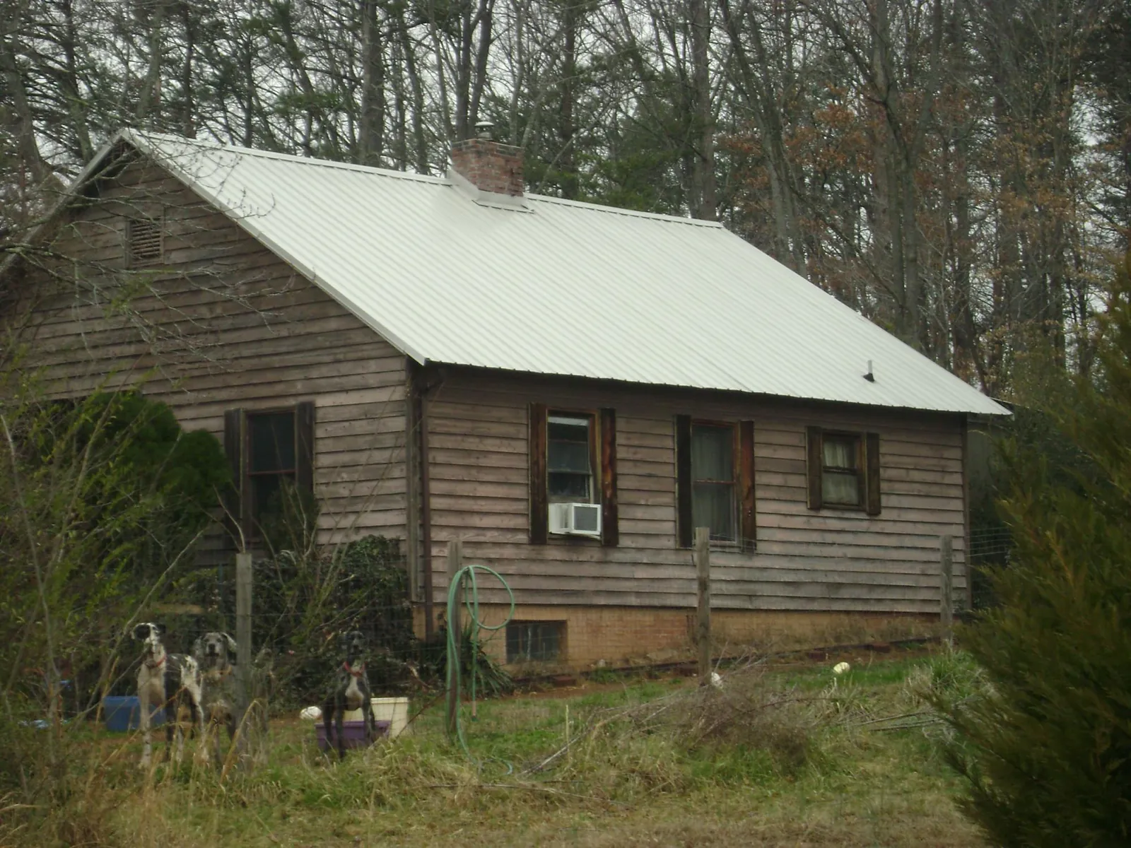 White metal roof on an old wood sided farmhouse, from a Metal Roof Installation job in Milan